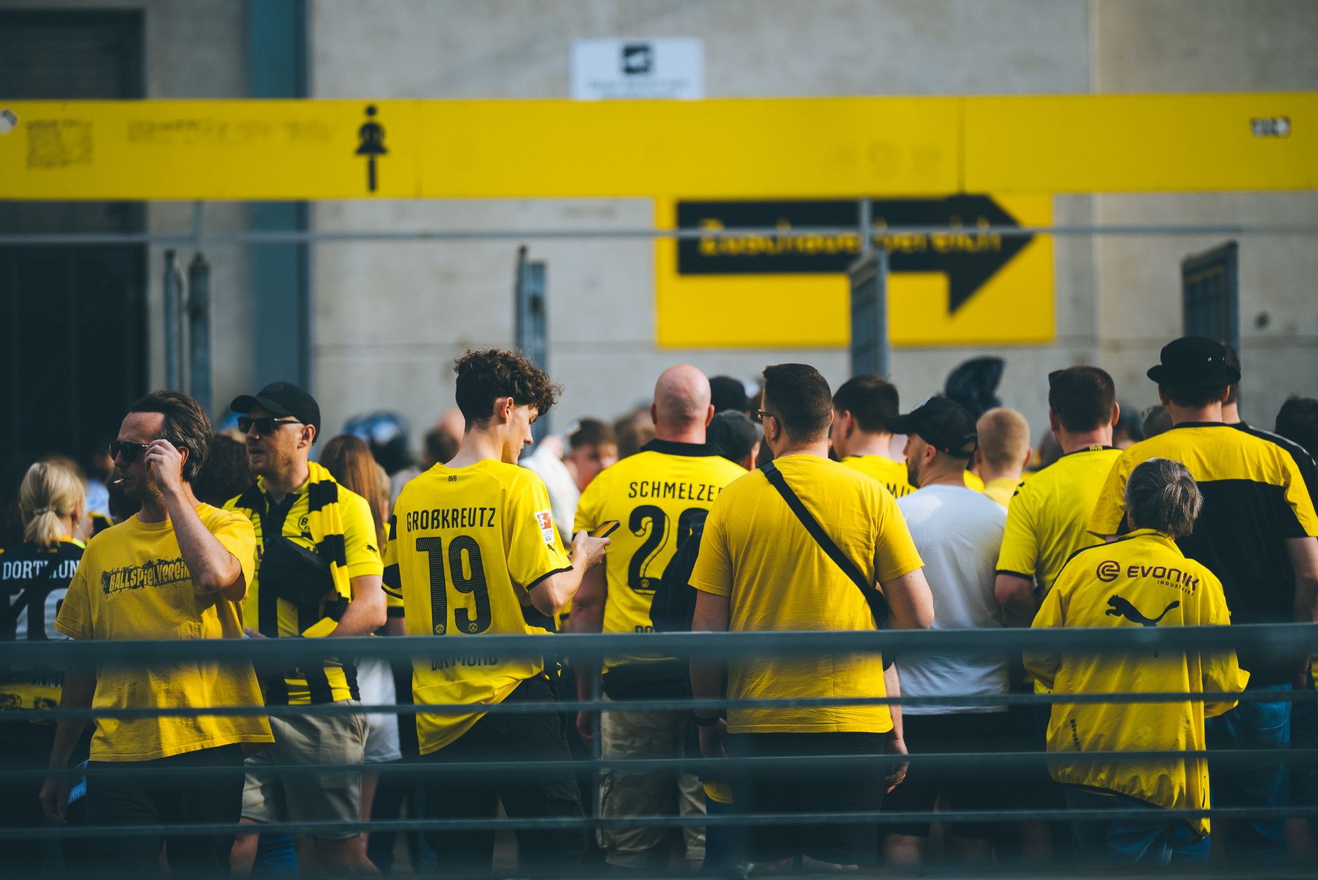 Fan hält Smartphone mit digitalem Fußballticket vor dem Stadioneingang in England
